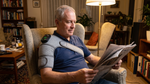 Man reading at home wearing SootheThera on his left shoulder
